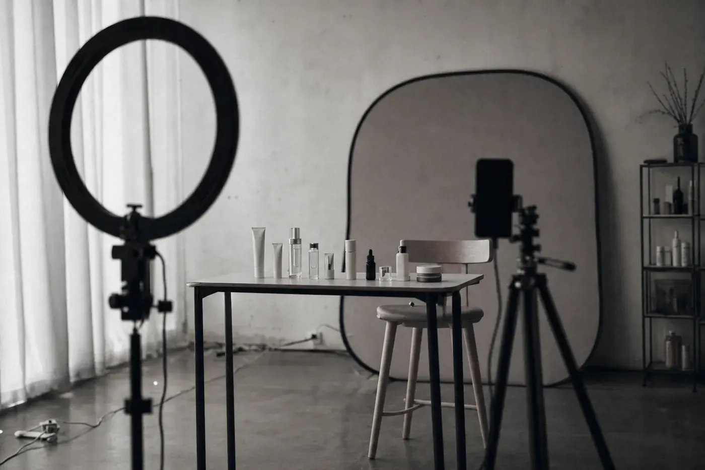 An empty livestream studio after hours, ring light off, skincare samples still lined up on the table