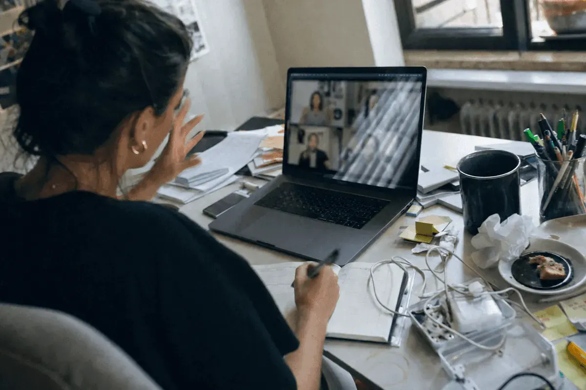 Brand manager taking handwritten notes during a video call brief