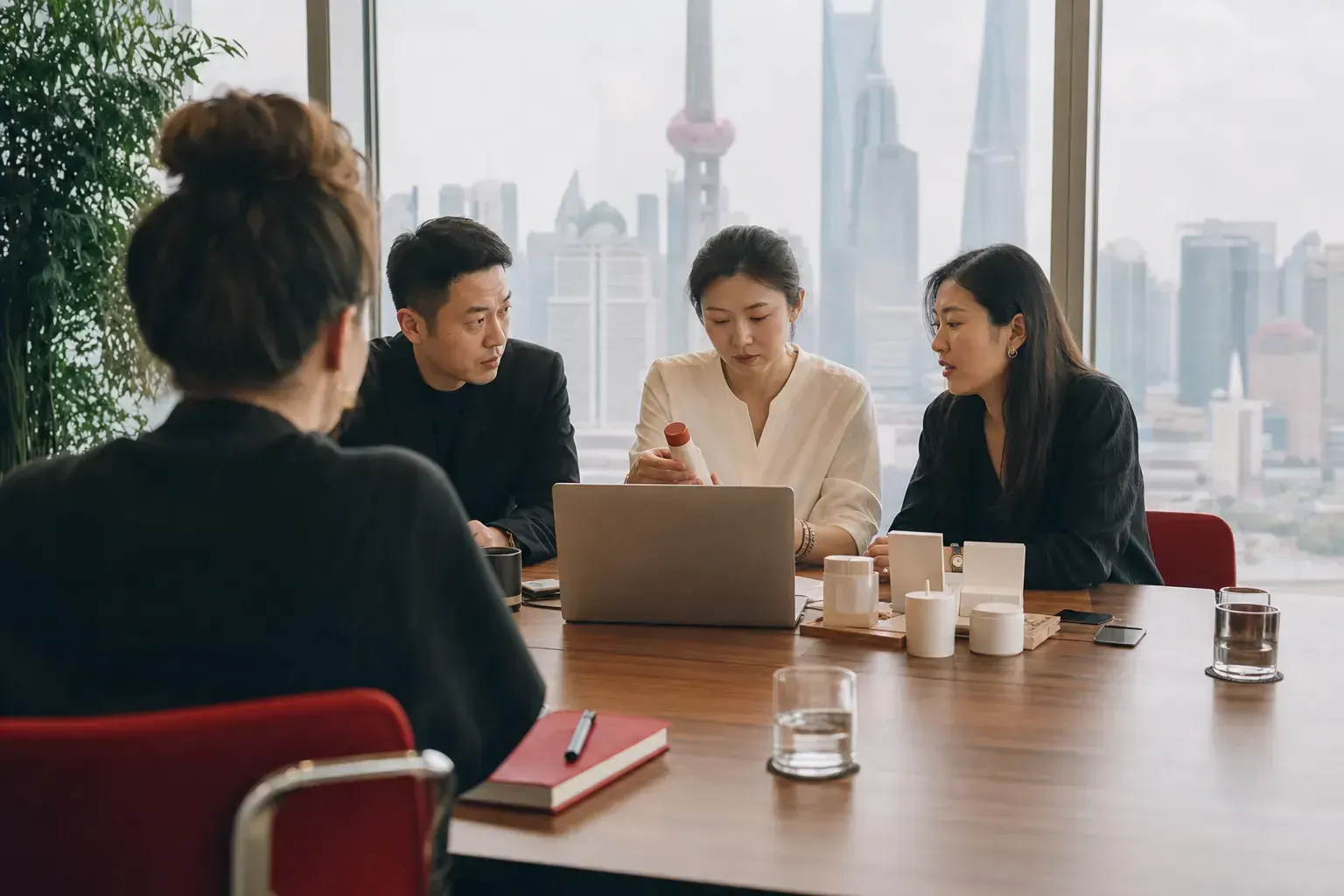 A foreign brand director facing a Chinese partner team across a meeting table in a Shanghai office