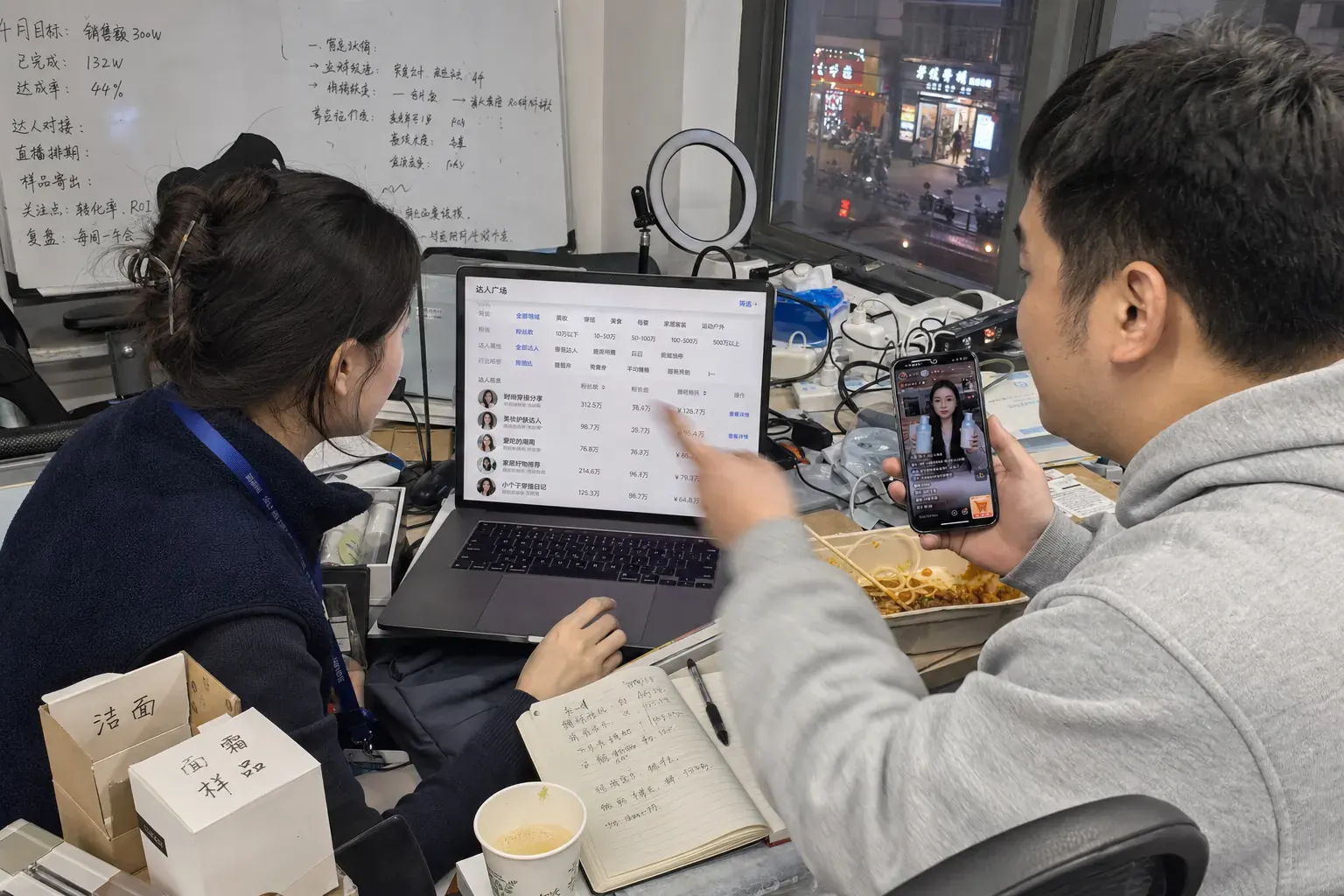 In einem Markenbüro in Changsha geht eine E-Commerce-Managerin am Laptop die Creator-Plaza von Douyin durch, während ihr Kollege auf dem Handy den Livestream eines Creators noch einmal abspielt.